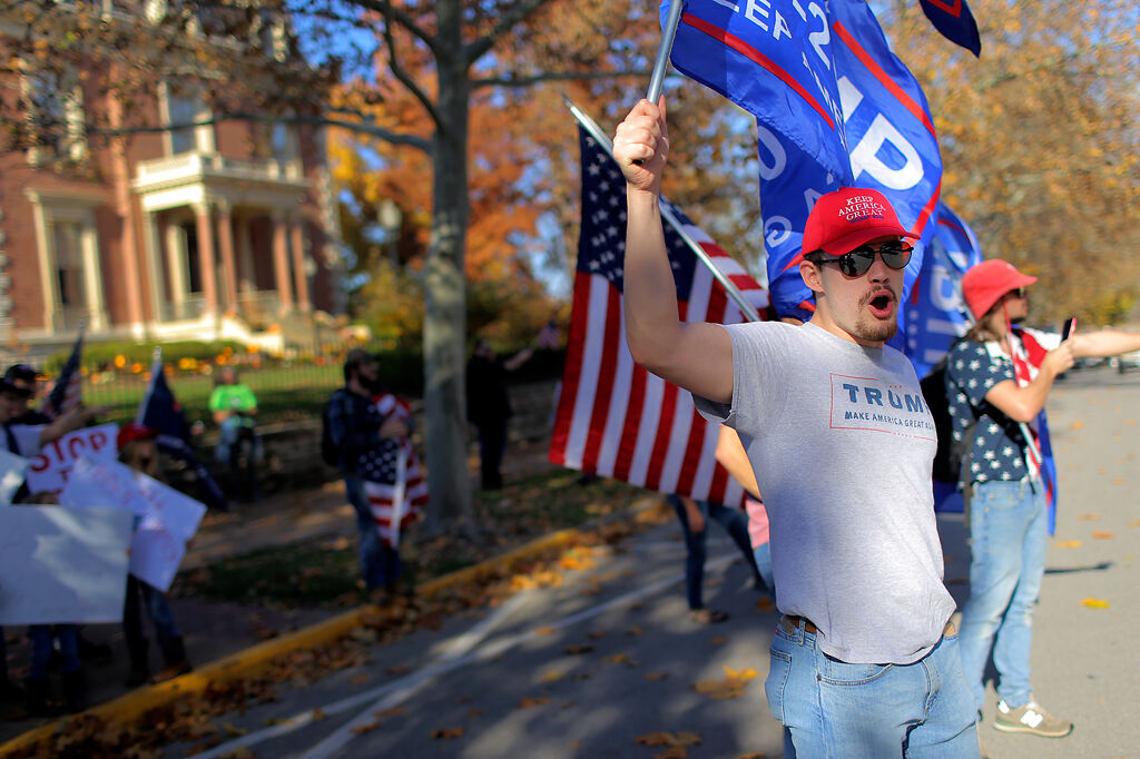 A supporter of President Donald Trump yells at a passing car